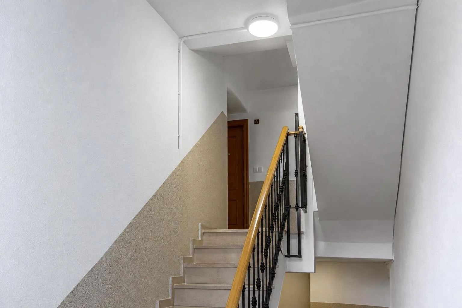 Escalera de un edificio con luminaria nueva y tubo bien instalado